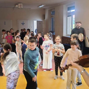 Dzieci bawią się w przepióreczkę. Dziewczynka goni koleżankę.