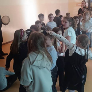 Dwie dziewczynki trzymając się za ręce przechodzą wzdłuż rzędu po przeciwnych stronach 