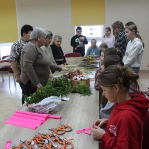 Prowadzące warsztaty członkinie KGW pokazują materiały przygotowane na palmy wielkanocne