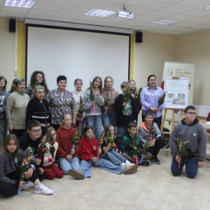 Uczetnicy warsztatów wraz z prowadzącymi pozują do zdjęcia grupowego z wykonanymi palmami wielkanocnymi