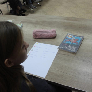 Książka, piórnik i karta z notatkami na stole