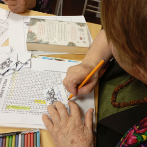 Seniorka zapisuje "dobre myśli" na ozdobnych karteczkach