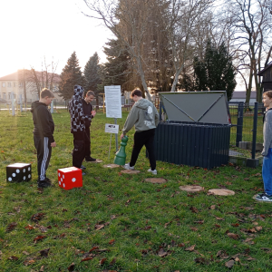 Na zdjęciu widać chłopców wokół pionków do gry terenowej, którzy są zaangażowani w rozgrywkę.