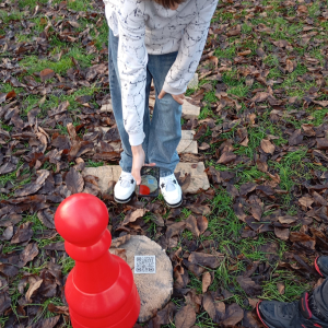 Na zdjęciu widać czerwony pionek, który znajduje się na planszy, tuż obok ręki chłopca.