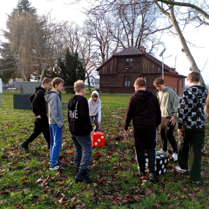Na zdjęciu widać chłopców wokół pionków do gry terenowej, którzy są zaangażowani w rozgrywkę.