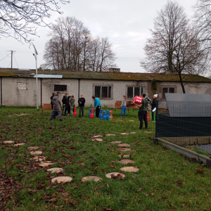 Na zdjęciu widać chłopców wokół pionków do gry terenowej, którzy są zaangażowani w rozgrywkę.