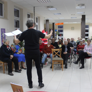 Autor Piotr Pilarski prezentuje swoje utwory, widownia słucha.