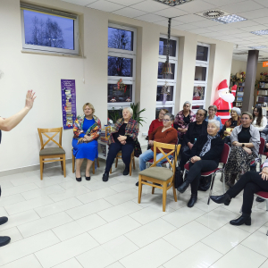 Ator Piotr Pilarski prezentuje swoje utwory, widownia słucha.