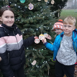 Dziewczynka z chłopcem pokazują zawieszone dekoracje