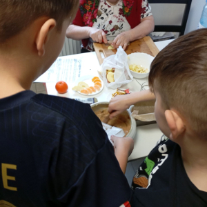 Dwóch chłopców z babcią przygotowują ciasto