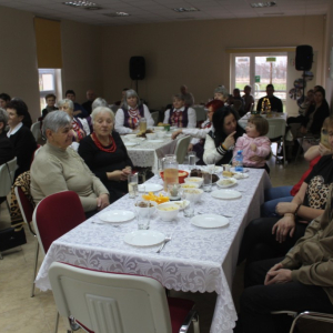 Uczestnicy wydarzenia siedzą przy stołach