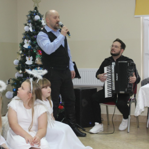 Mężczyzna z mikrofonem obok mężczyzna gra na akordeonie