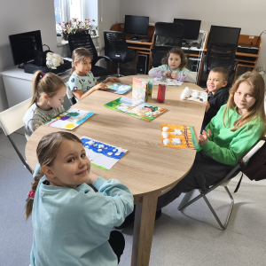 Dzieci pozuja do zdjęcia z gotowymi pracami plastycznymi.