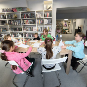 Grupa dzieci pracująca nad swoimi pracami.