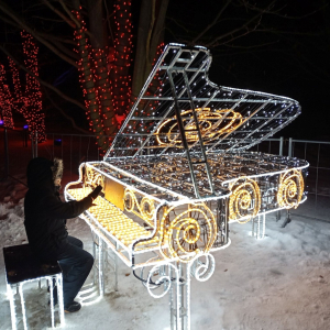 Chłopiec przy świetlnej instalacji w kształcie fortepianu