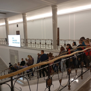 Grupa zwiedzających schodzi schodami gmachu Sejmu RP do hallu głównego.