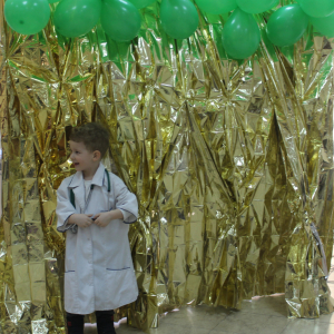 Mały chłopiec w białym fartuchu lekarskim na złotym tle.