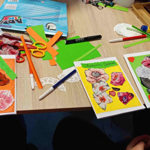 Na stole leżą trzy laurki dla babci i dziadka, wykonane przez dzieci.