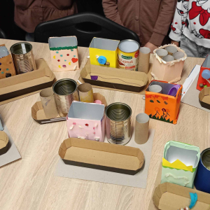 Na stole prezentacka wykonanych organizerów , wykonanych z opakowań, które dzieci wykonały podczas drugiego spotkania. 