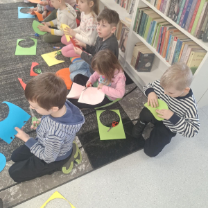 Dzieci wycinają z papieru kolorowe koła.