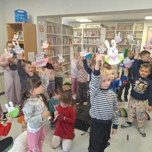 Dzieci trzymają w rękach wykonane podczas zajęć papierowe króliczki.