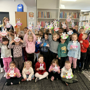 Dzieci pozują do zdjęcia z wykonanymi podczas zajęć króliczkami wielkanocnymi.