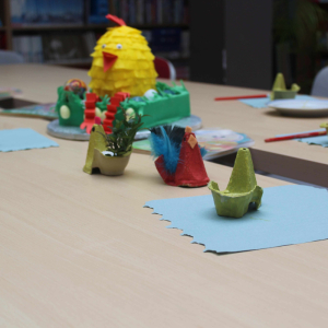 Na stole leżą materiały potrzebne do wykonania wielkanocnego kurczaczka.