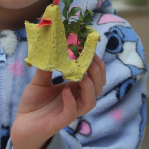 Dziecko trzyma wykonanego podczas zajęć kurczaczka.