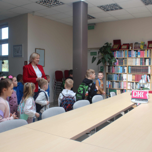 Dzieci i bibliotekarka w czytelni biblioteki