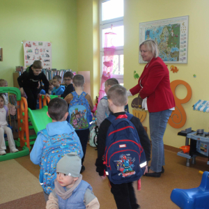 Kobieta kieruje dziećmi w kolejce do żjeżdżalni w sali małego czytelnika 