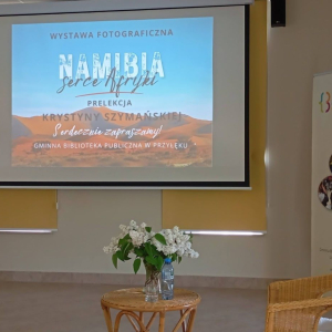 Na dużym ekranie wyświetlona prezentacja wystawy fotograficznej „Namibia – serce Afryki”.
