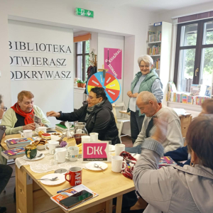 Grupa seniorów rozmawiają między sobą.
