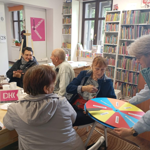 Bibliotekarka podaje koło fortuny kobiecie.