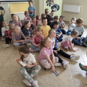 Dzieci siedzą w grupie na podłodze
