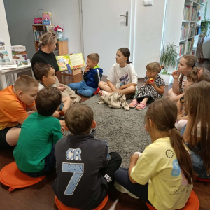 Bibliotekarka czyta grupie dzieci książkę o Przygodach Fenka