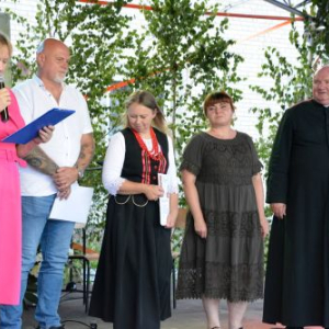Kierownik biblioteki odczytuje protokół konkursowy, obok stoi komisja i Ks. Szczepan Barański