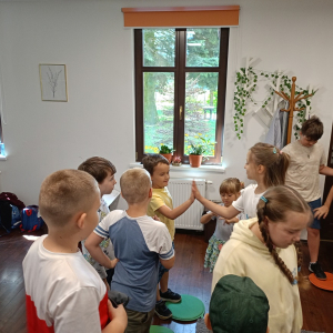 Grupa dzieci stoją w kręgu.