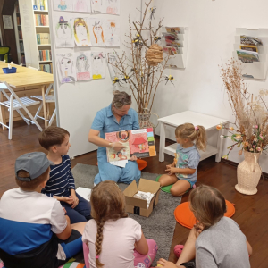 Bibliotekarka pokazuje grupie dzieci stronę w książce o zmyśle smaku