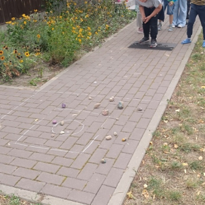 Chłopiec rzuca kamyczkiem do celu