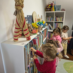 Przedszkolaki oglądają książki na półkach