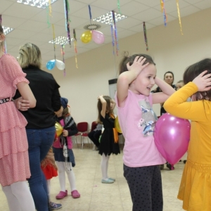 Dziewczynki stoją przed sobą trzymając pomiędzy balonik