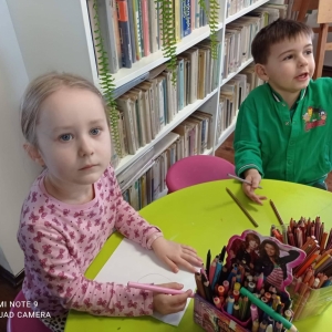 Dziewczynka z chłopcem siedzą przy stoliczku