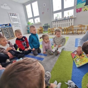 Kobieta pokazuje zebranym obrazki w książce