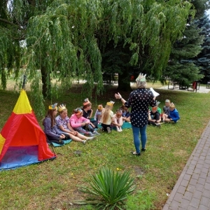 Opiekun z dziećmi obok namiotu tipi