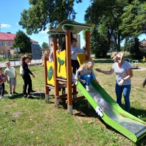 Dzieci razem z opiekunem podczas zabawy na placu zabaw