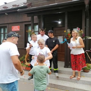 Uczestnicy Dożynek stoją razem przed budynkiem biblioteki