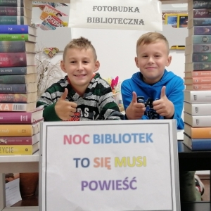 Dwóch chłopców podnosi kciuki w górę w fotobudce.