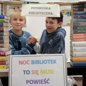 Dwóch chłopców ściska sobie dłonie w fotobudce.