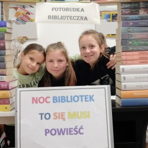 Trzy uśmiechnięte dziewczynki w fotobudce.