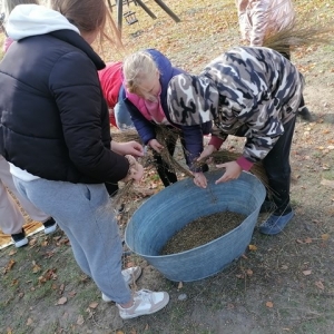 dzieci pochylają się nad starą balią